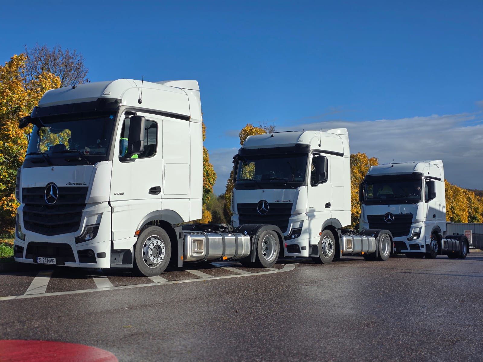 fleet of modern white freight trucks lined up at a European logistics company headquarters