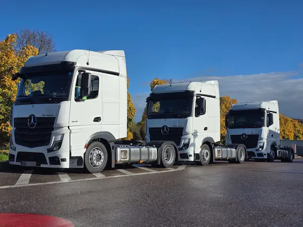 fleet of modern white freight trucks lined up at a European logistics company headquarters